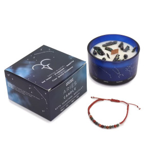 Vela energética del zodiaco Aries con pulsera de piedras preciosas y vaso de vidrio azul con constelaciones.