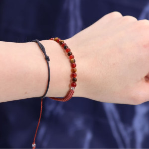 Pulsera de piedras preciosas del zodiaco Leo colocada en la muñeca, con cordón ajustable y acabado artesanal.