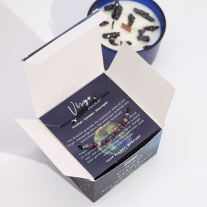 Interior de la caja del zodiaco Virgo con pulsera de piedras preciosas colocada sobre tarjeta ilustrada y presentación cuidada.