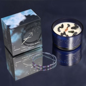 Vela energética del zodiaco Sagitario con envase de vidrio azul, caja ilustrada con constelaciones y pulsera de piedras.