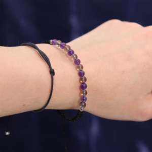 Pulsera de piedras preciosas en tonos violetas y ahumados asociada al zodiaco Capricornio, hecha a mano y ajustable.