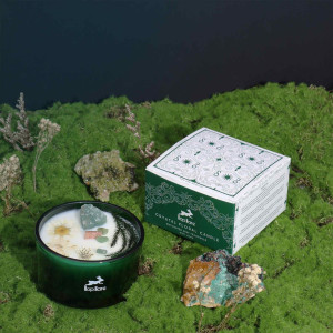 Vela energética El Mago con cristales y flores secas en ambiente natural.