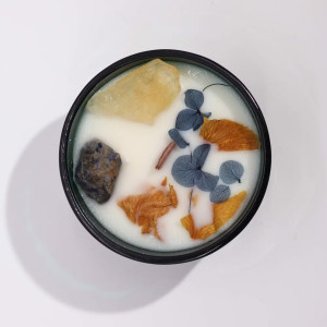 Vela energética de soja con cristales naturales y flores secas para rituales naturales y energía positiva.