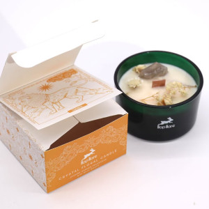 Caja ilustrada de vela artesanal sostenible con símbolos de fuerza y energía positiva.