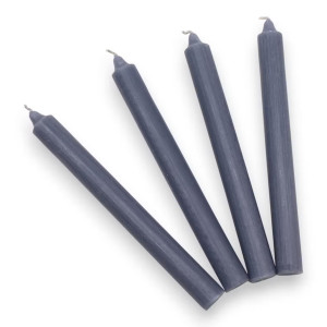 Detalle de velas grises de candelabro con acabado sobrio y textura rústica.