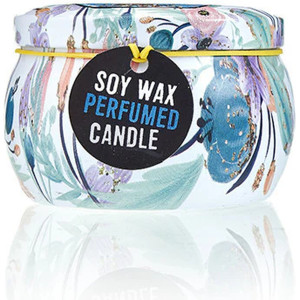 Vela de soja en lata ilustrada con diseño artístico de muñeca y tapa decorativa cerrada.