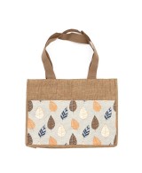 Bolsa de yute natural con estampado de hojas tropicales para transporte diario.