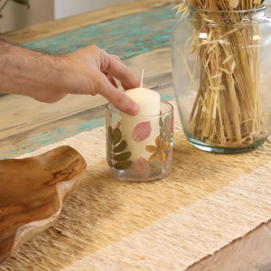 Vista superior del portavelas pequeño de vidrio reciclado con hojas secas visibles.