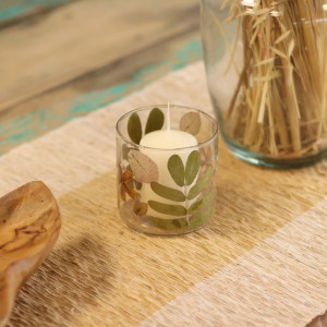 Detalle del cristal reciclado con hojas y flores secas encapsuladas en portavelas pequeño.