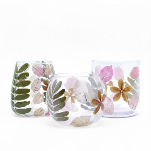 Portavelas de vidrio reciclado con hojas secas visibles disponible en 3 diseños.