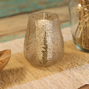 Vista con vela interior del portavelas mediano con vegetación prensada en vidrio texturizado.