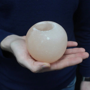 Portavelas redondo de sal del Himalaya tallado en sal del Himalaya y su tamaño en la mano.