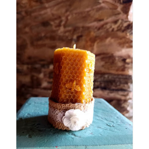 Vista superior de vela de cera de abeja natural con mecha visible y superficie sin procesar.