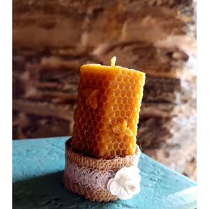 Vista lateral de vela decorativa de cera de abeja natural mostrando su forma cilíndrica.