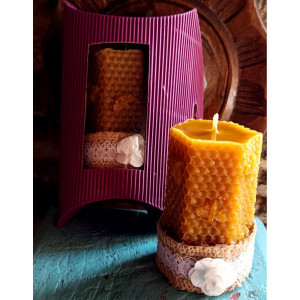 Vela de cera de abeja natural junto a su packaging tipo sobre para protección y presentación.