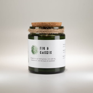 Vela de soja aroma higo y grosella negra en frasco de vidrio verde con tapa de corcho.