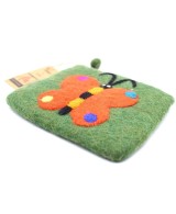 Detalle de lana afieltrada en monedero artesanal decorado con mariposa.