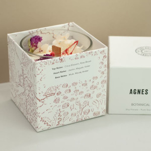 Presentación completa de vela botánica con caja ilustrada y envase de vidrio para decoración y regalo.