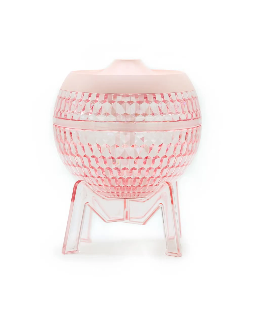 Difusor de aromas USB rosa con diseño transparente y luz LED para aceites esenciales.