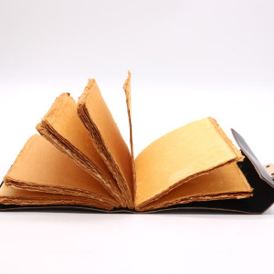 Libro abierto mostrando sus 200 páginas de papel natural y borde irregular, perfectas para rituales y escritos personales.