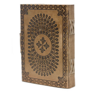 Cuaderno de cuero con diseño mandala en entorno cálido, ideal para escritura espiritual.