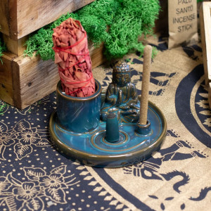 Soporte multiusos de cerámica azul con buda, varilla de incienso y sahumerio colocado para uso aromático.