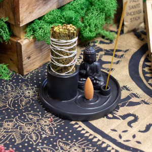 Soporte multiusos de cerámica azul con buda, varilla de incienso y sahumerio colocado para uso aromático.