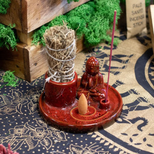 Soporte multiusos de cerámica azul con buda, varilla de incienso y sahumerio colocado para uso aromático.