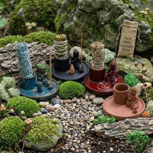 Soporte multiusos de cerámica azul con buda, varilla de incienso y sahumerio colocado para uso aromático.