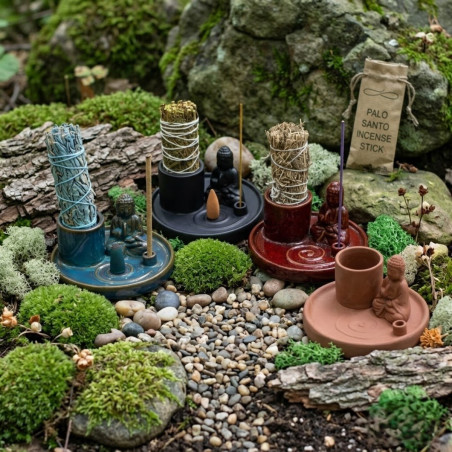 Soporte multiusos de cerámica azul con buda, varilla de incienso y sahumerio colocado para uso aromático.