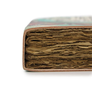 Cuaderno de cuero en ambiente cálido, simbolizando inspiración y bienestar espiritual.