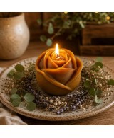 Vela  con forma de rosa de cera de abeja con mecha encendida.