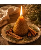 Vela de fresa encendida y decorada con canela.