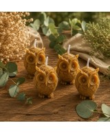 Pack de cuatro velas búho elaboradas con cera de abeja natural sobre mesa decorativa.
