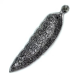 Portainciensos tibetano alargado con figura de buda en metal para varillas sobre superficie clara.