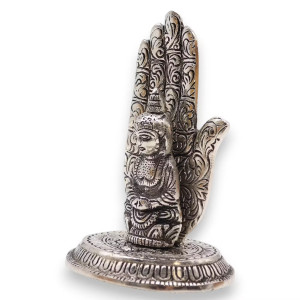 Portaincienso en forma de mano con figura de buda en metal para varillas sobre base decorativa.