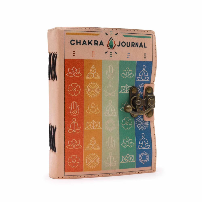 Detalle del cuaderno de cuero claro con símbolos de chakras, irradiando equilibrio y energía vibrante.