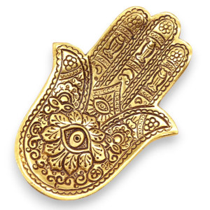 Portainciensos hamsa dorado de metal para varillas con grabado decorativo sobre superficie clara.