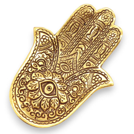 Portainciensos hamsa dorado de metal para varillas con grabado decorativo sobre superficie clara.
