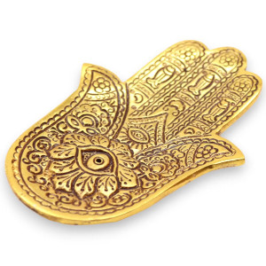 Portainciensos hamsa dorado de metal para varillas con grabado decorativo sobre superficie clara.