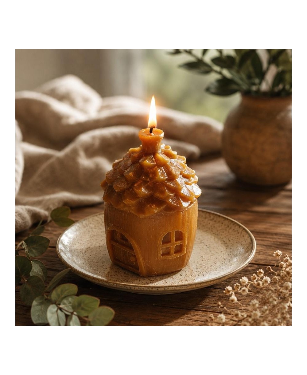 Vela casita de cera de abeja natural con mecha encendida.