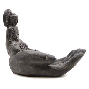 Quemador de incienso mano de buda colocado como elemento decorativo en espacio de relajación.