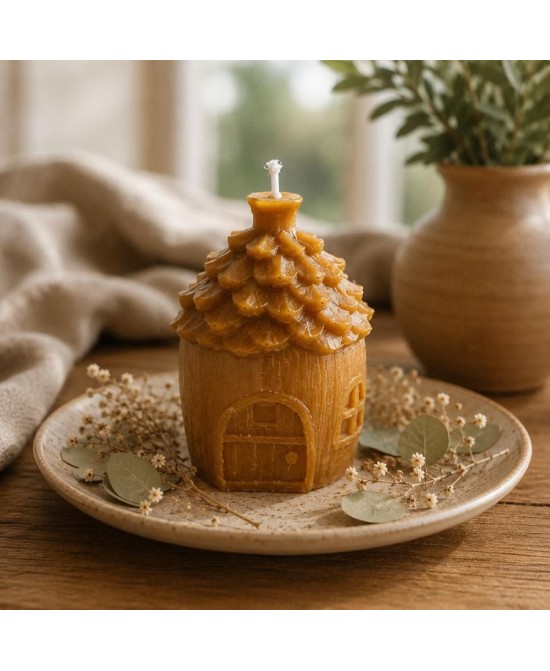 Vela decorativa con forma de casita elaborada en cera de abeja natural.