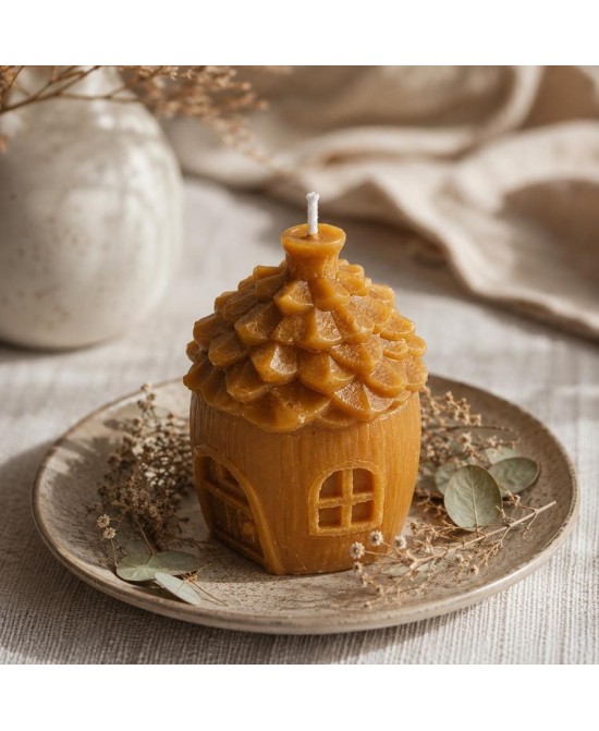 Presentación de vela casita de cera de abeja natural sobre plato decorativo.