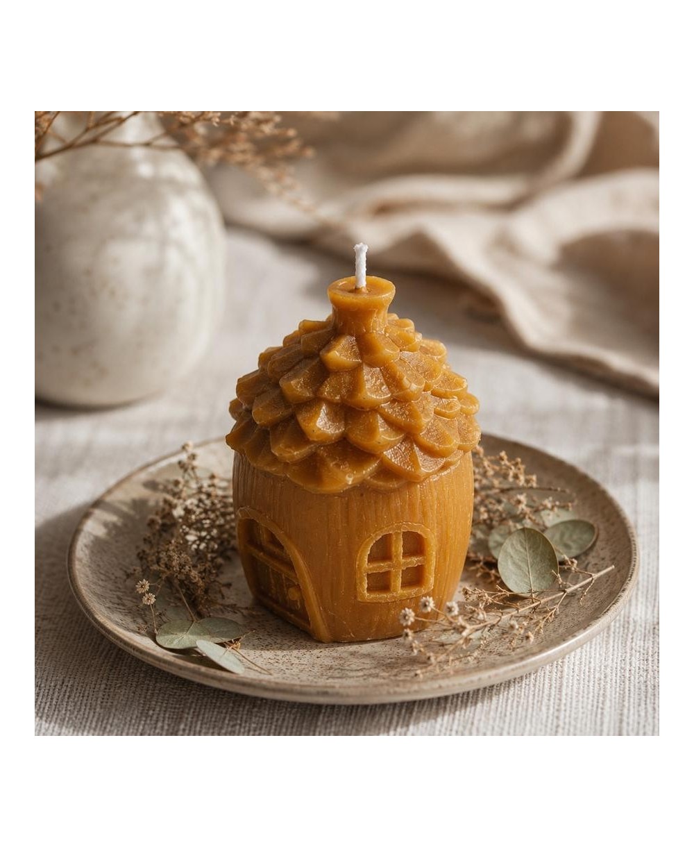 Presentación de vela casita de cera de abeja natural sobre plato decorativo.