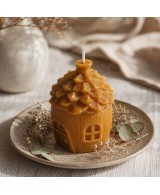 Presentación de vela casita de cera de abeja natural sobre plato decorativo.