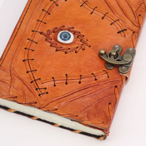Vista frontal del cuaderno con cierre metálico antiguo y diseño de ojo protector.